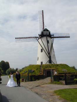 Eine alte Windmhle mit Hochzeitspaar an Kanal nach Brgge.